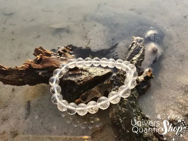 cristal de roche vertus en lithothérapie, bracelet 08mm sur une branche d'arbre au bord de l'eau