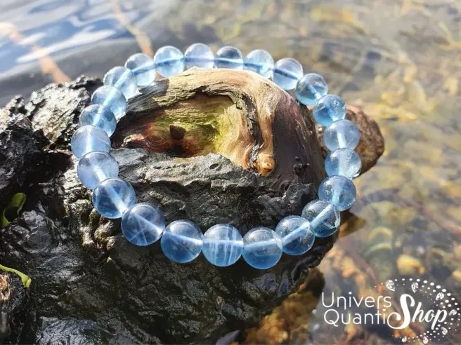 fluorite bleue vertus, bracelet fluorine bleue sur tronc d'arbre au bord d'un lac