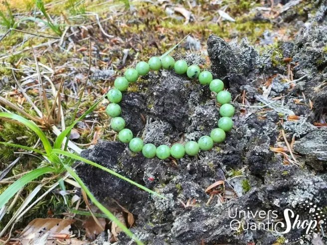 jade néphrite verte bracelet 08mm posé sur de l'herbe dans la forêt