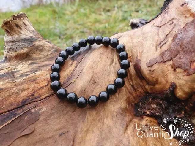 onyx noir vertus bracelet 8mm posé sur un arbre dans la nature