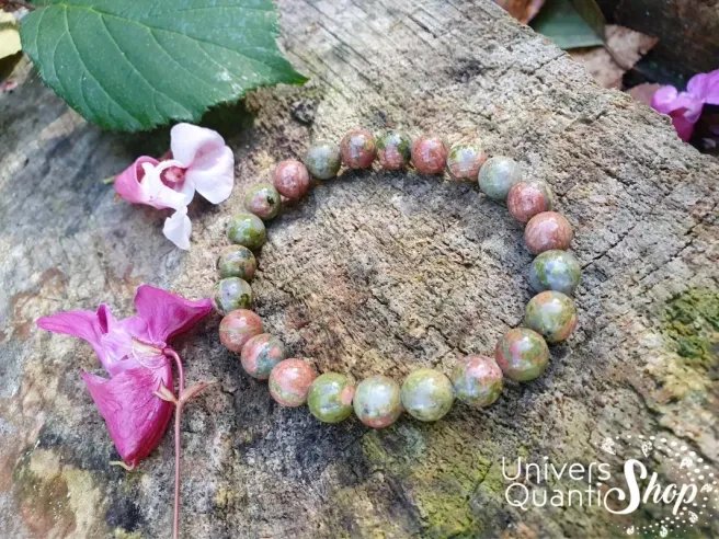 unakite bracelet pierre naturelle 08mm sur un rocher avec des fleurs