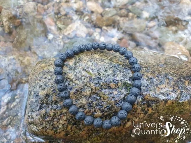pierre de lave bracelet pierre volcanique noire 6mm posé sur un rocher
