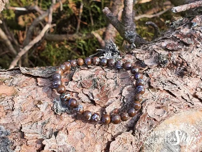 opale boulder australie bracelet 6mm posé sur une écorce d'arbre