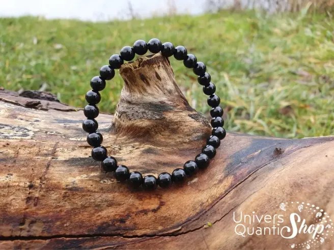 bracelet onyx pierre noire naturelle 6mm posé sur un arbre