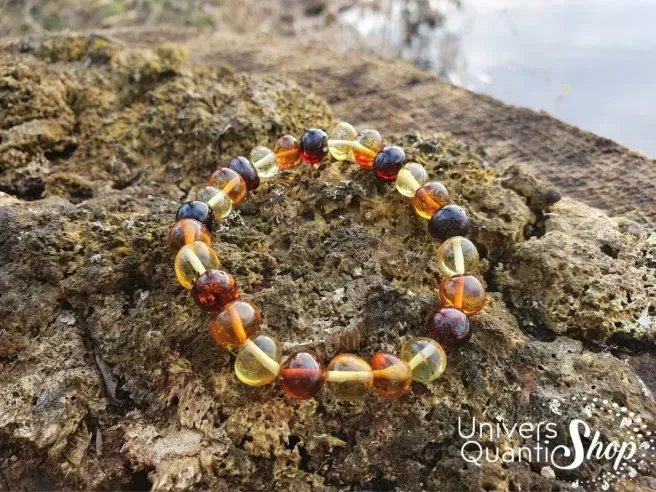bracelet ambre véritable pierres roulées posé sur un morceau de bois