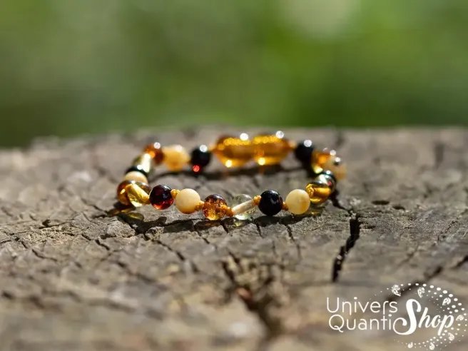 bracelet ambre bebe multicolore sur une souche d'arbre, univers quantic shop