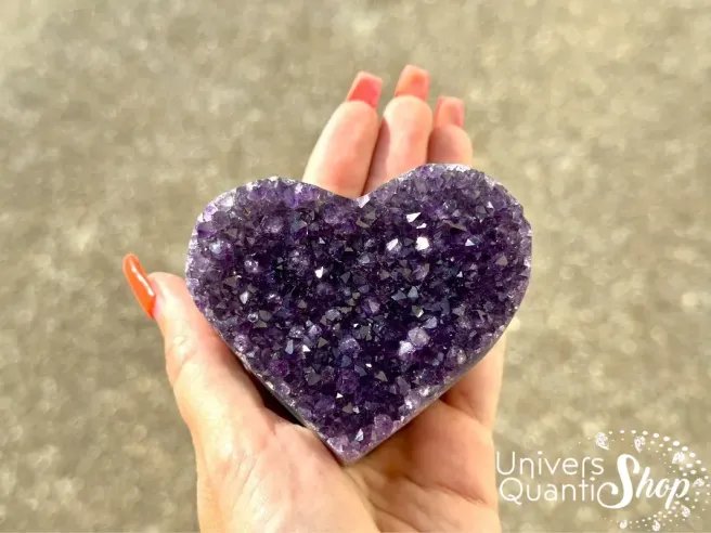 améthyste propriétés, pierre violette de sagesse en forme de coeur posé dans une main