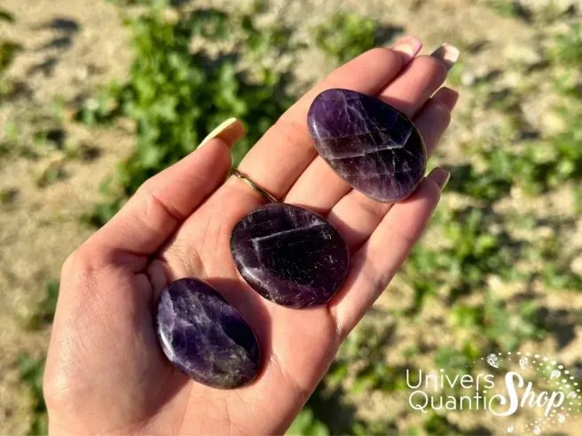 améthyste pierre plate, pierre violette naturelle posée dans une main