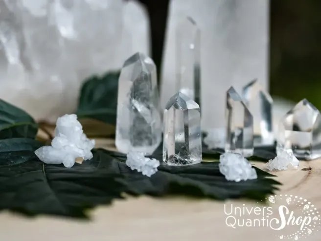 cristal de roche pointes de différentes tailles sur une feuille avec amas de quartz en fond