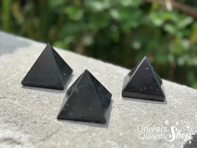 pyramides tourmaline noire posées sur une dalle en extérieur