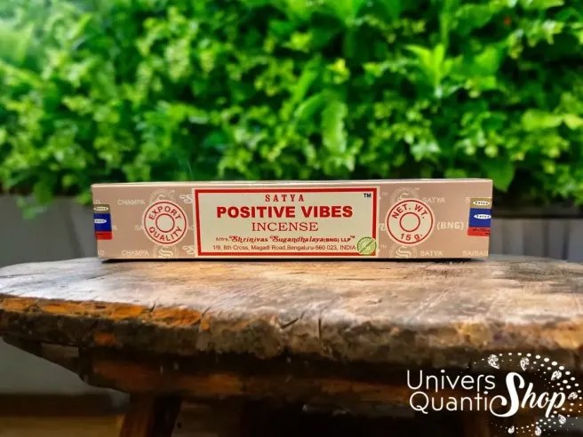 encens satya positive vibes posé sur une petite table en bois en extérieur