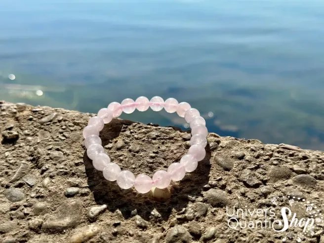 quartz rose bracelet en pierre naturelle rose posé au bord d'un lac