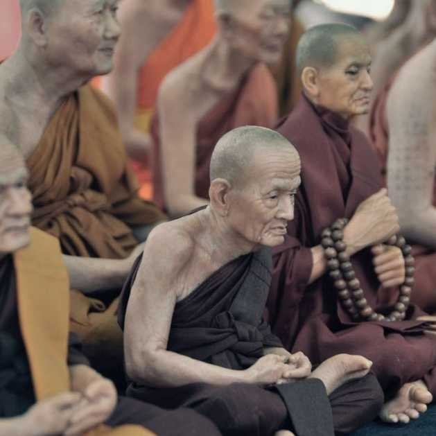 Les origines de la méditation. Groupe de moines bouddhistes priant dans un temple.