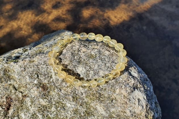 citrine chauffée bracelet de 8mm sur un rocher au bord de l'eau